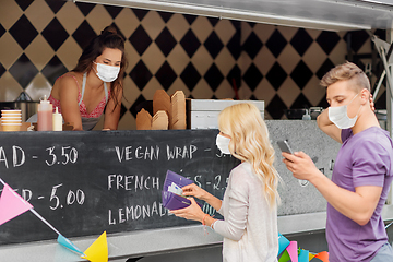 Image showing seller and customers in masks at food truck