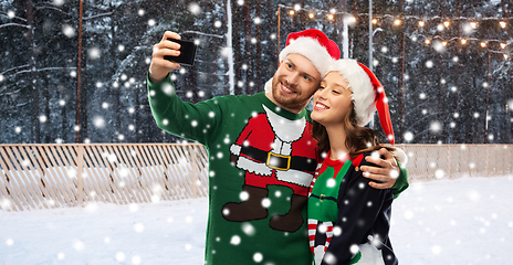 Image showing happy couple in christmas sweaters taking selfie