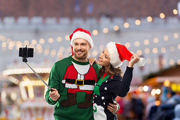 Image showing happy couple in christmas sweaters taking selfie