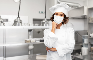 Image showing female chef in mask at restaurant kitchen