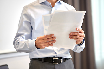 Image showing close up of businessman with papers at office