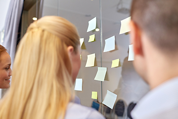 Image showing business team with sticky notes on glass at office