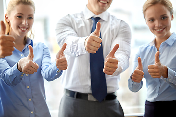 Image showing happy business team showing thumbs up at office