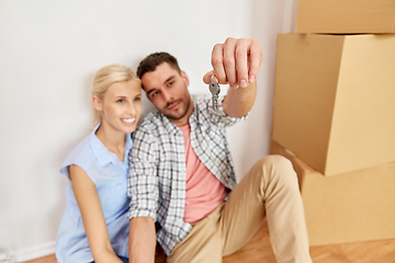 Image showing happy couple with key and boxes moving to new home