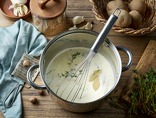 Image showing pot with hot mixed milk cream and herbs 