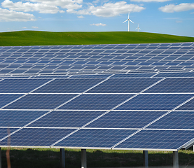 Image showing Rows of solar panels, wind turbine and green nature