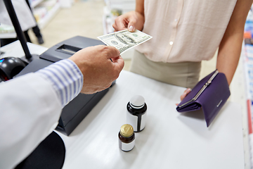 Image showing pharmacist taking money from customer at pharmacy