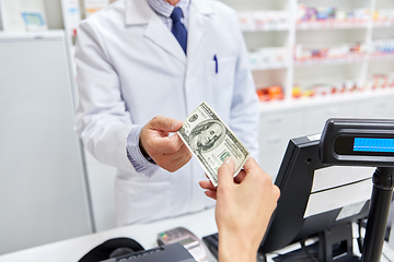 Image showing pharmacist taking money from customer at pharmacy