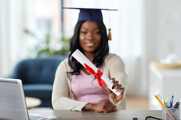 Image showing graduate student with laptop and diploma at home