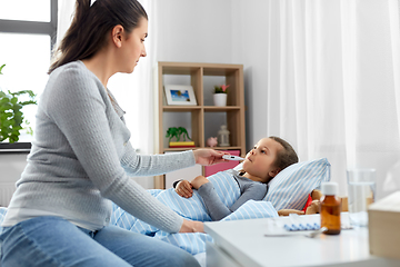 Image showing mother and sick daughter measuring temperature