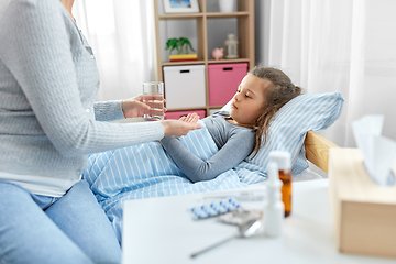 Image showing mother giving medicine to sick little daughter