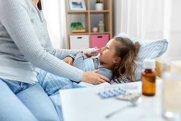 Image showing mother with nasal spray treats sick daughter