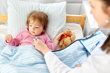 Image showing doctor with stethoscope and sick girl in bed