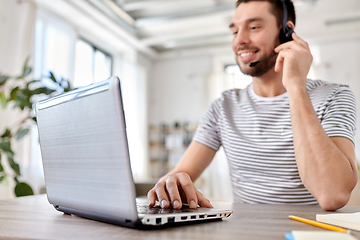 Image showing man with headset and laptop working at home