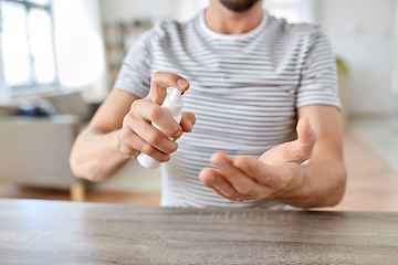 Image showing close up of man with hand sanitizer at home office