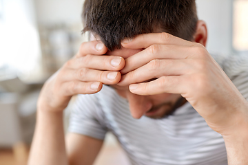 Image showing close up of stressed man having headache at home