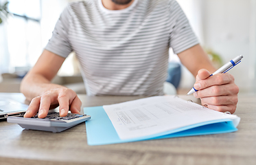 Image showing man with files and calculator works at home office