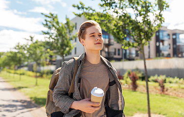 Image showing young man with backpack drinking coffee in city