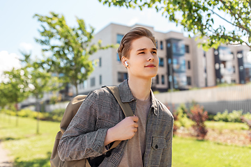 Image showing young man with earphones and backpack in city