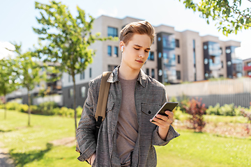 Image showing teenage boy with earphones and smartphone in city