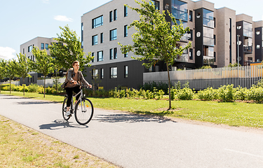 Image showing young man riding bicycle on city street