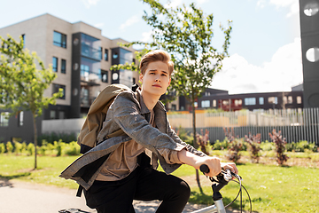 Image showing young man riding bicycle on city street