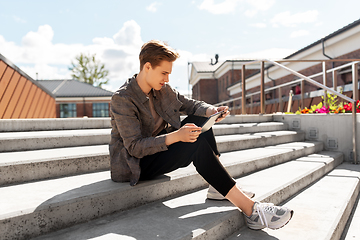 Image showing young manor teenage boy with tablet pc in city