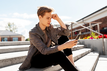 Image showing teenage boy using smartphone in city