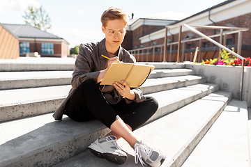 Image showing young man with notebook or sketchbook in city