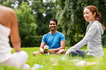 Image showing group of people sitting on yoga mats at park