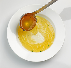 Image showing chicken broth pouring into soup plate