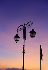 Image showing Beautiful vintage street lamp against a bright sunrise sky