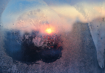 Image showing Ice pattern and water drops on glass on a sunny winter morning