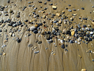 Image showing Wet sea pebbles on the sand