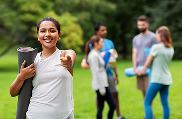 Image showing woman with yoga mat pointing finger to camera