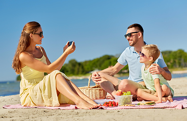 Image showing family with smartphone photographing on beach