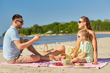 Image showing family with smartphone photographing on beach