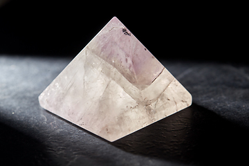 Image showing quartz crystal pyramid on slate stone in darkness