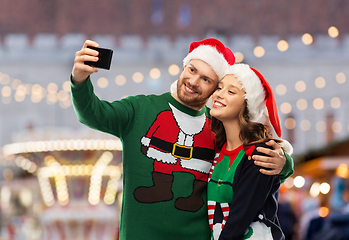 Image showing happy couple in christmas sweaters taking selfie