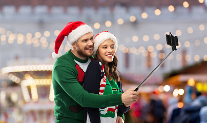 Image showing happy couple in christmas sweaters taking selfie