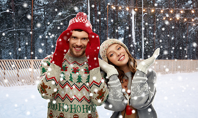 Image showing couple in ugly sweaters on christmas ice rink