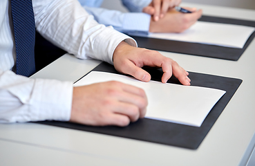 Image showing close up of businessman with papers at office