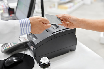 Image showing close up of hand giving bank card to pharmacist