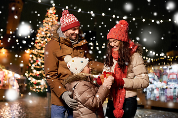 Image showing happy family with gift at christmas market in city