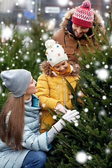 Image showing happy family choosing christmas tree at market