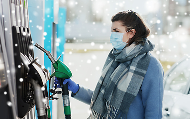 Image showing young woman wearing medical mask at gas station