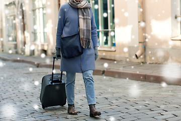 Image showing woman with travel bag walking along empty street