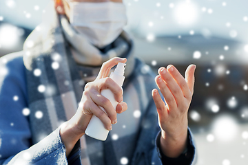 Image showing close up of woman spraying hand sanitizer