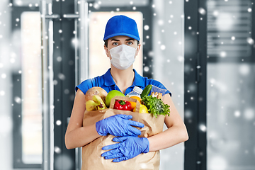 Image showing delivery woman in face mask with food in paper bag