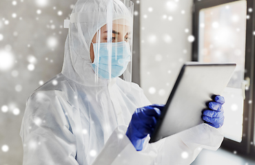 Image showing doctor in protective wear with tablet computer